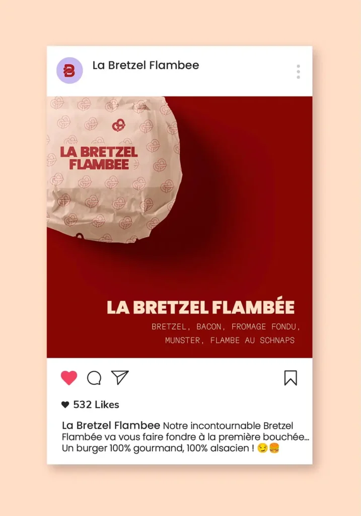 Mockup d’un post Instagram pour le restaurant La Bretzel Flambée avec un burger emballé avec le branding sur fond rouge. Packaging aux motifs alsaciens.